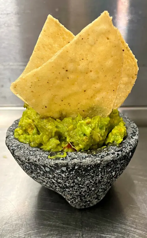 Freshly made authentic Mexican guacamole served in a traditional stone molcajete with crispy tortilla chips at Las Patronas taqueria in Cypress, TX.